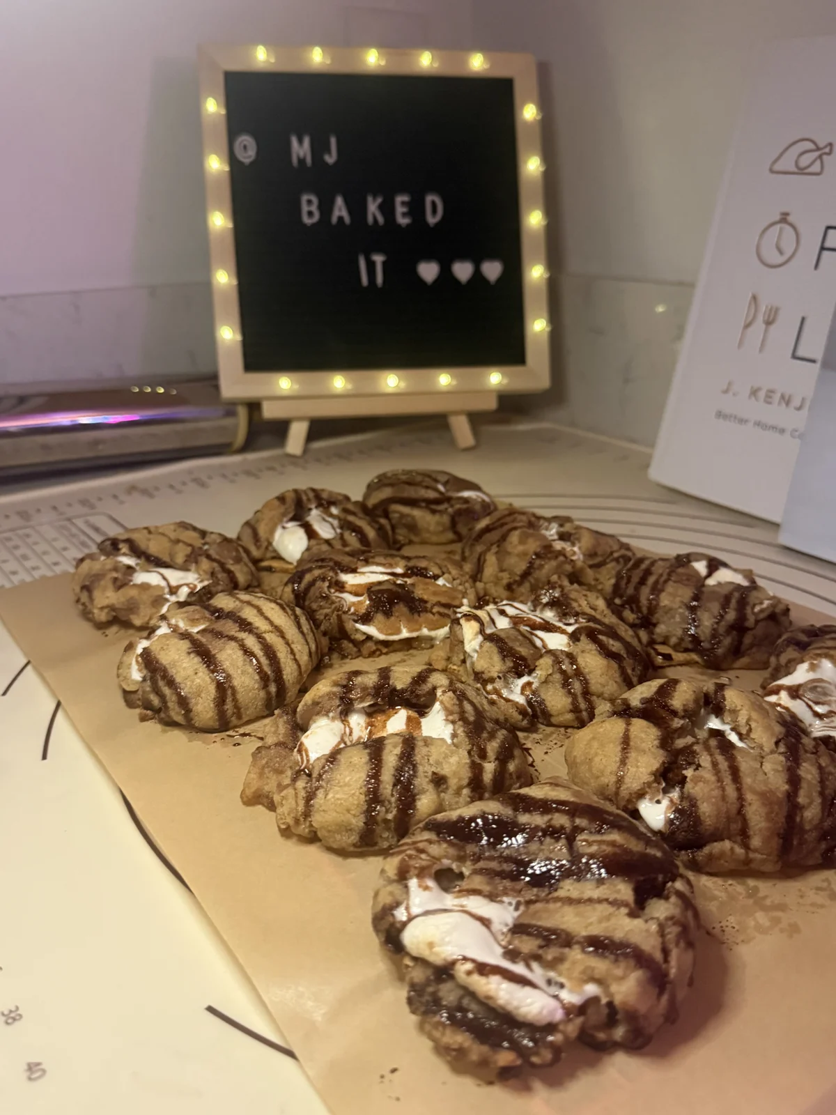 Cookie trays beside the MJ Baked It sign
